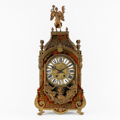 une horloge en or surmontée d'un ange