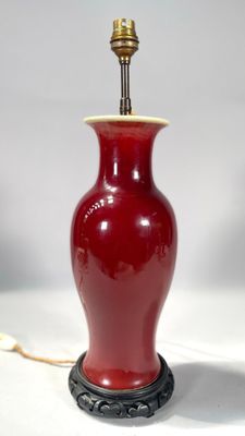 une lampe rouge posée sur une table blanche