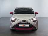 the front of a silver toyota yaris parked in a white room