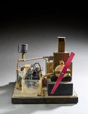une maquette miniature d'une machine à vapeur avec une poignée rose