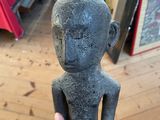 someone is holding a small statue of a man in a room