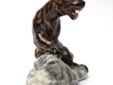 a figurine of a tiger sitting on top of a rock