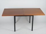 La table est en bois et ses pieds sont en métal noir.