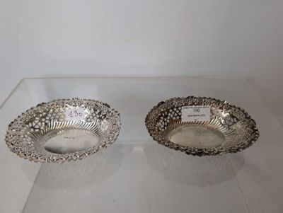 pair of silver plated bowls on display in a glass case