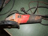 a picture of a corded sander on a green surface