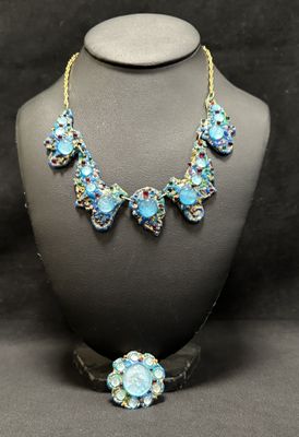 a close up of a necklace and earrings on a mannequin