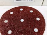 an image of a red sanded disc with holes on it