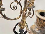 a candle holder that has a statue on top of it