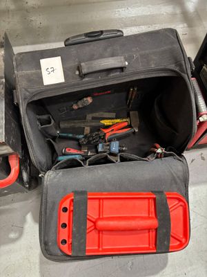 un sac contenant des outils, posé par terre