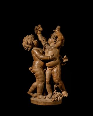 statue of a boy and a girl holding hands on a black background