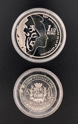 un gros plan d'une pièce de monnaie posée sur une surface noire, avec un reflet