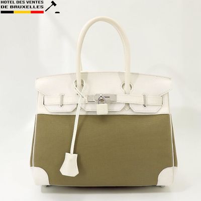 une photo d'un sac à main blanc et vert sur lequel est accrochée une étiquette