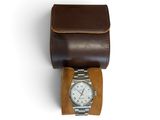 brown leather watch case with a watch on top of it