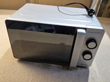 a microwave that is sitting on the floor in the room