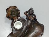 a statue of a woman holding a vase on a table