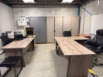 une pièce équipée d'un bureau, de chaises et d'un tableau blanc accroché au mur