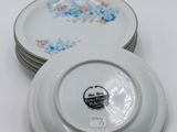 several white plates with floral designs are stacked on top of each other