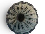 a close up of a vase on a white surface