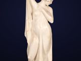 a white marble statue of a woman holding a flag