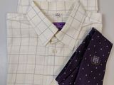 une chemise blanche et une cravate violette posées sur une table