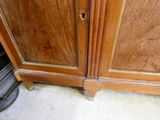 a wooden cabinet with a door that has a hole in it
