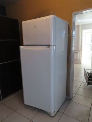 un réfrigérateur blanc trônant au milieu d'une cuisine