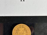 a close up of a gold coin on display in a glass case