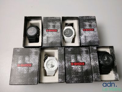 Plusieurs montres se trouvent dans une boîte posée sur une surface blanche