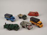 several toy trucks are lined up in a circle on a white surface