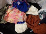 une pile de vêtements posée sur un lit