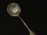a silver spoon with a flower design on it
