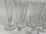 several empty wine glasses are lined up on a white surface