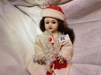 a doll that is sitting on a white sheet
