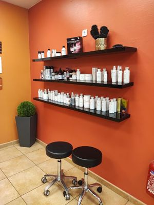 a room with a lot of bottles of hair products on the shelves