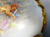 a small figurine sitting on top of a white vase