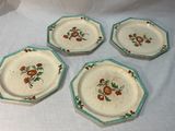 quatre assiettes ornées de fleurs, posées sur une table blanche