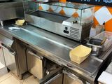stainless steel counter top in a restaurant kitchen with a sign on the wall