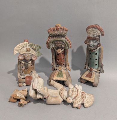 trois figurines en céramique représentant des Amérindiens et un bébé allongé par terre