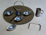 a silver plate with spoons and a silver pitcher on it