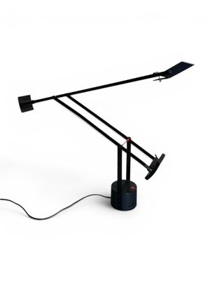 a black table lamp with a black base and a white background