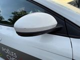 a close up of a car ' s side mirror with the reflection of a building in the background