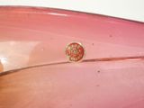 a close up of a pink glass bowl with a red label on it