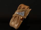 gros plan d'une bague en or et diamants sur une surface noire