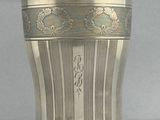 un vase en argent posé sur une table, sur fond blanc
