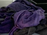 purple and black towels are sitting on a counter in a kitchen