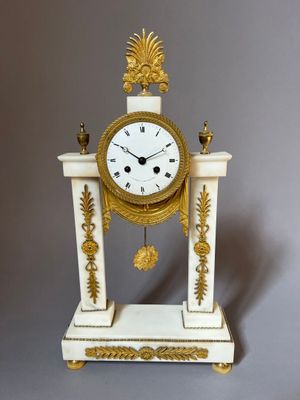 a white and gold clock sitting on top of a table