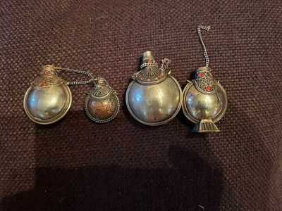 trois cuillères anciennes en argent sont posées sur un tissu marron