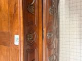 a large wooden cabinet with a mirror on the wall