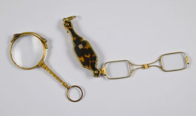 une paire de ciseaux et une loupe posés sur une table