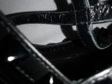 a close up of a black purse with a black strap